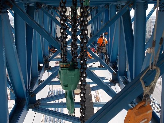 Ironworkers prepare to dismantle the 85 ton hub & spindle transfer truss, first suspending the weight of it from the newly erected chain fall platform above.