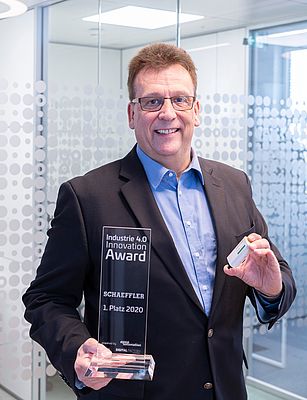 Rauli Hantikainen, Responsabile del settore strategico Industria 4.0, con l’Industry 4.0 Innovation-Award e un sensore OPTIME