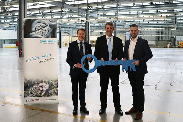 Die beiden geschäftsführenden Gesellschafter Mathias Stendtke (l.) und Roland Lenzing (r.) bei der Schlüsselübergabe mit Thomas Velten (Magna Powertrain) im neuen Produktionsgebäude.