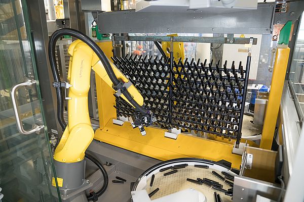 Der Roboterarm bestückt die Haken vollautomatisch, bevor das Gestell ins Galvanikbad getaucht wird. © Baumer