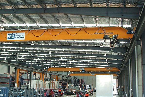 The 22 m wide overhead cranes run on beams that span the entire length of the factory, all three are synchronized for speed and ramp times