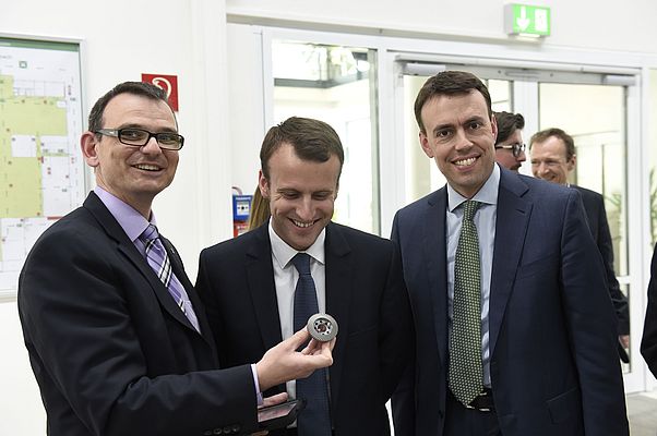 Emmanuel  Macron entouré à droite de Jochen Schlick de la direction de Wittenstein et à gauche de Nils Schmid ministre de l’économie de Baden Wurtemberg.